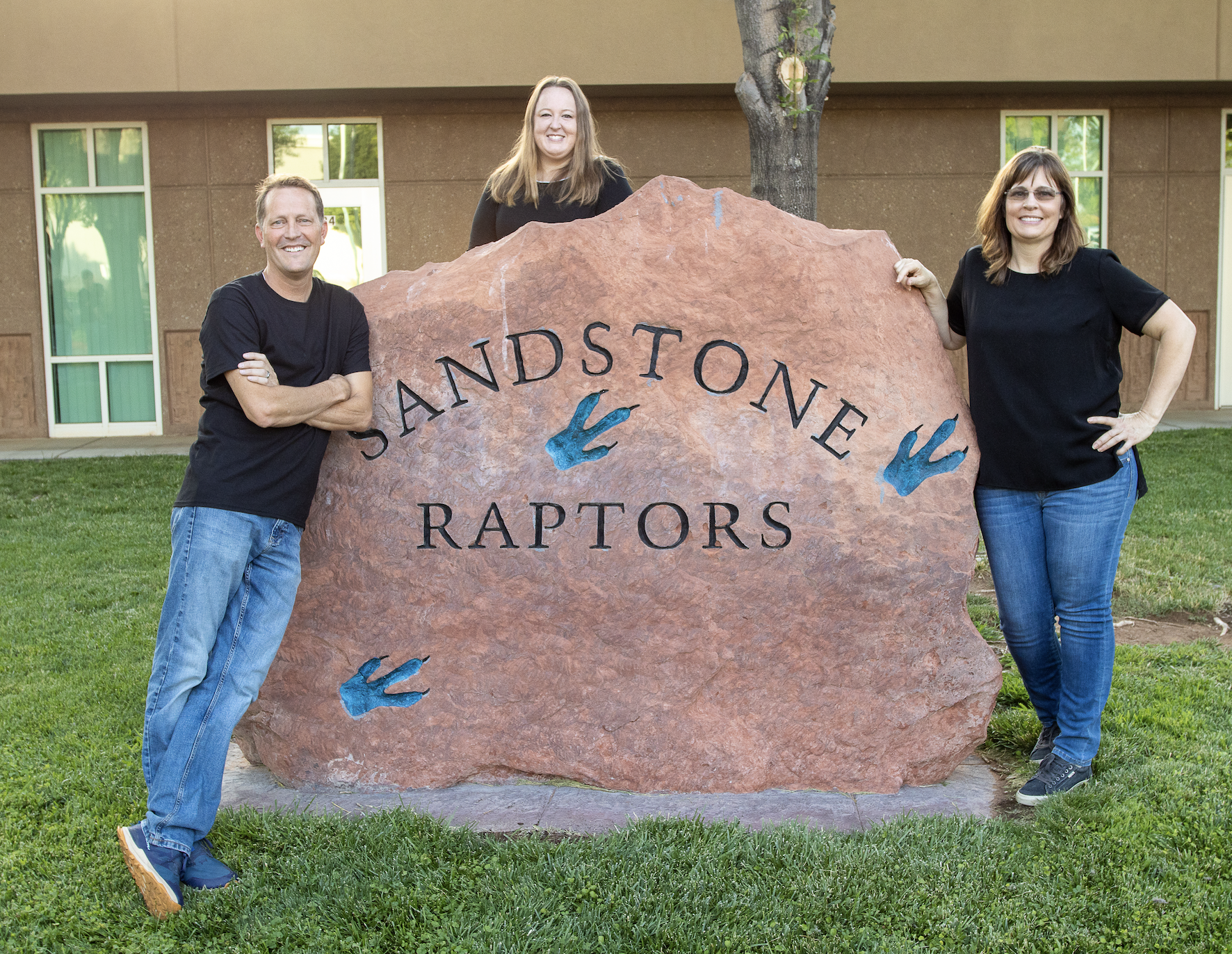 Three third grade teachers standing near the Sandstone Rock.